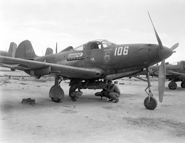Оружейники подвешивают бомбу к P-39